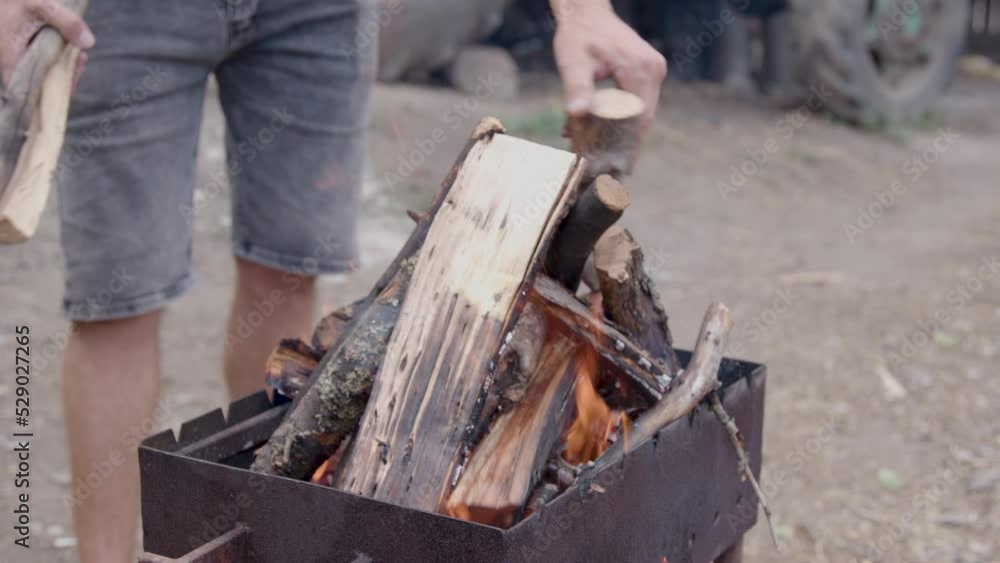 man prepares to light the fire with long cut wood. wood placed in a brazier for baking. close up image