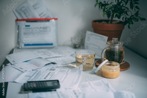 Lots of utility bills and a calculator on the table. No one. A kitchen table with a bunch of unpaid bills for electricity  gas  utilities.