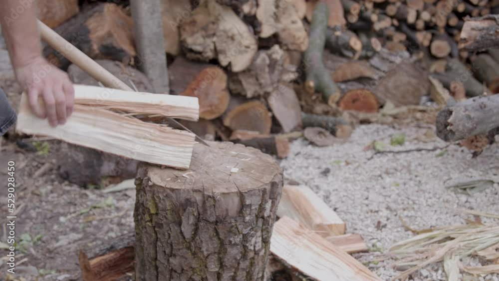 man working to split wood with an axe, then with his hands. man prepares wood for winter man working to split wood with an axe, then with his hands. man prepares wood for winter