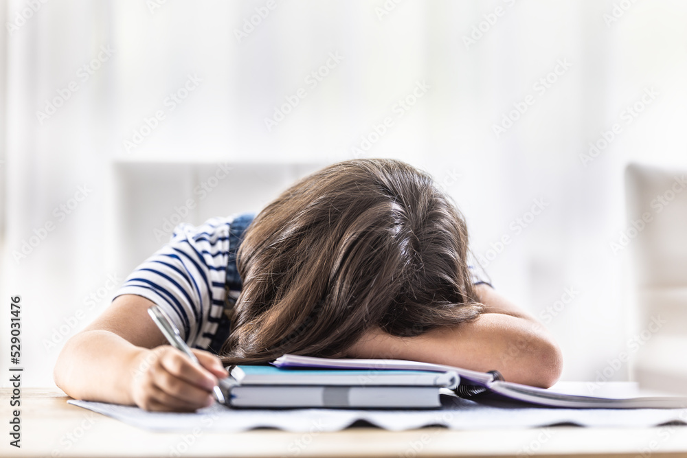 Desperate girl student has her head fallen on her arm during making homework at home Desperate girl student has her head fallen on her arm during making homework at home