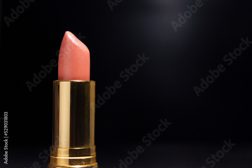 Golden Lipstick for Pink Color, in Black background for Advertising.