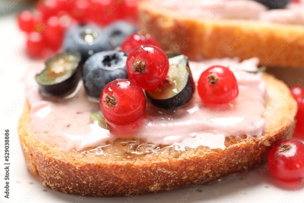 Tasty sandwiches with cream cheese, blueberries and red currants, closeup