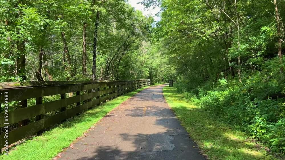 Moving along a bike trail with a fence alongside Moving along a bike trail with a fence alongside