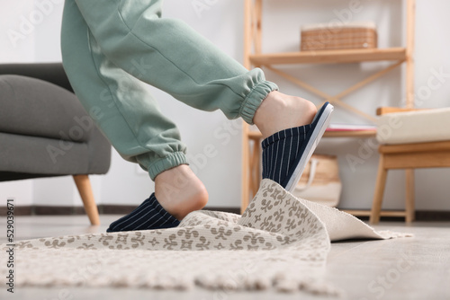 Fotografie Man tripping over rug at home, closeup