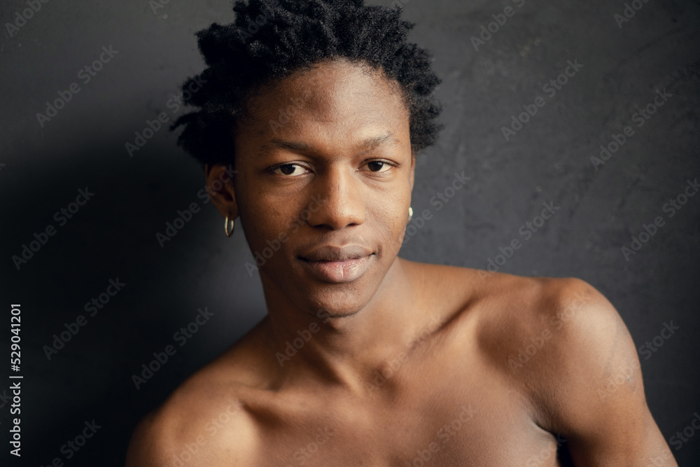 smiling young african man on a black background. copy space