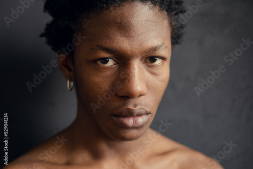 young african american man with serious expression on black background. copy space