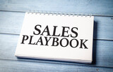 sales playbook text on blue wooden background