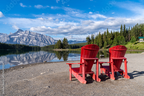 Two Jack Lake with the iconic red adirondack chairs at the shoreline in Banff National Park photo