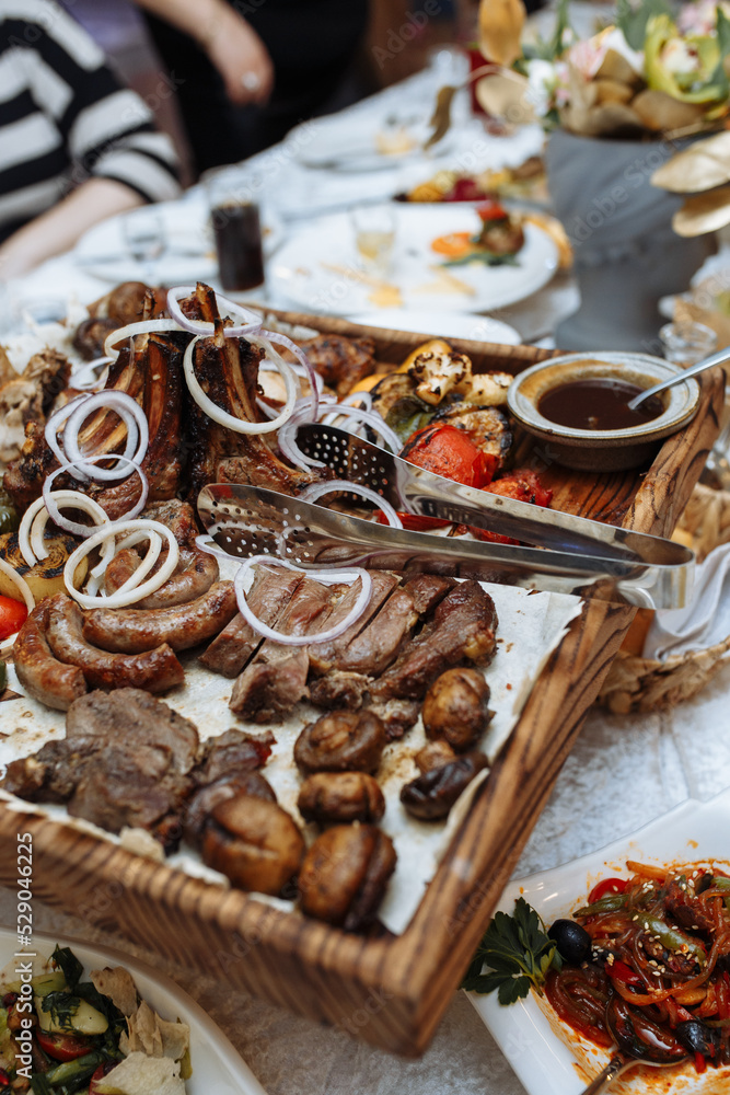 grilled meat set on a wooden board on the table grilled meat set on a wooden board on the table