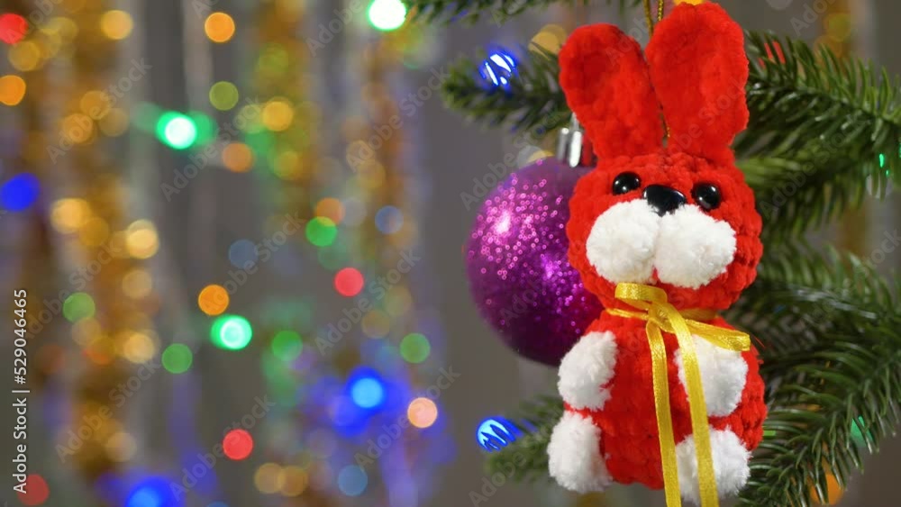 A red hare on a Christmas tree against a background of multi-colored flashing lights in defocus A red hare on a Christmas tree against a background of multi-colored flashing lights in defocus