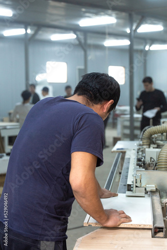 a worker in the shop.in the manufacture of furniture stands with his back