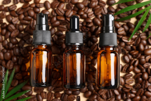 Flat lay composition with bottles of organic cosmetic products and coffee beans on beige background