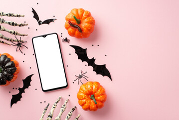 Halloween concept. Top view photo of pumpkins smartphone bat silhouettes skeleton hands spiders centipede and confetti on isolated pastel pink background with copyspace