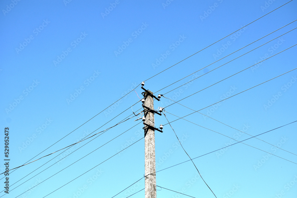 pole with wires against the blue sky, close-up