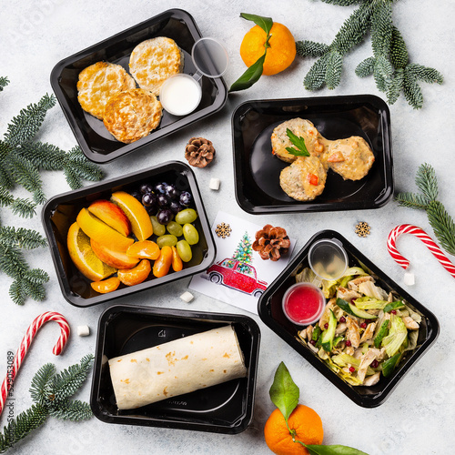 Restaurant healthy food delivery in take away boxes for daily nutrition on white stone background, christmas background photo