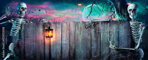 Fotografija Halloween Party - Skeletons With Wooden Banner In Spooky Nights