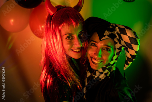Friends in costume smiling in a halloween indoor party