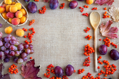 Autumn background with colorful fruits and leaves on a jute fabric