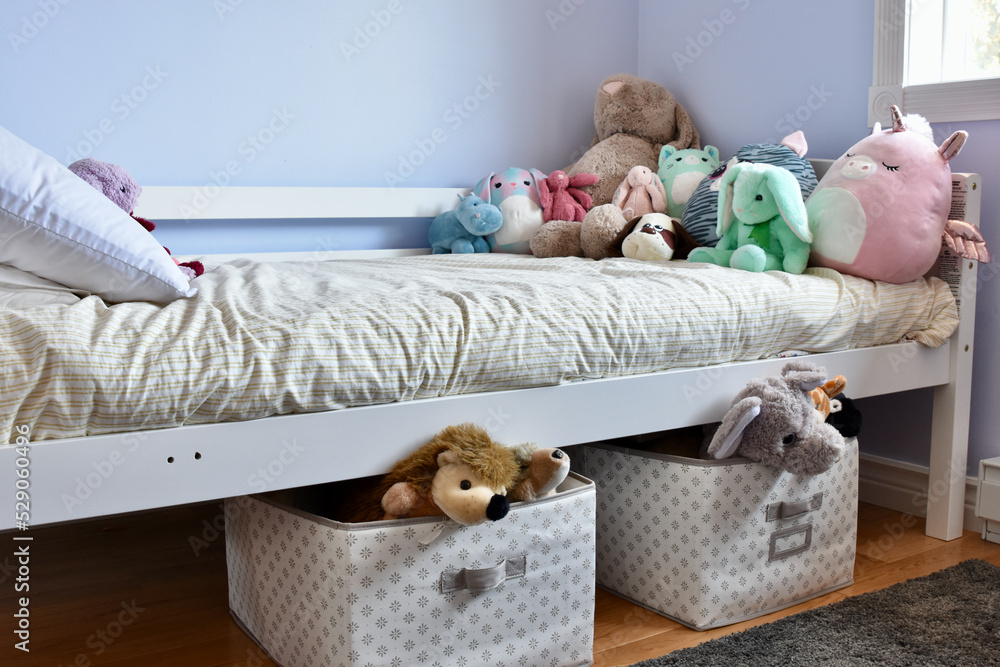 Modern child's room with favourite stuffies on bed and simple storage solution ideas for toys under the bed