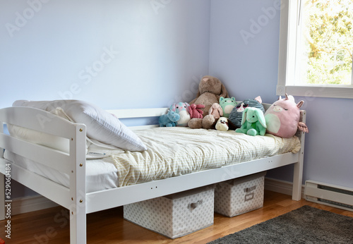 Simple, pretty girls bedroom with cute cuddly stuffies and easy storage solutions