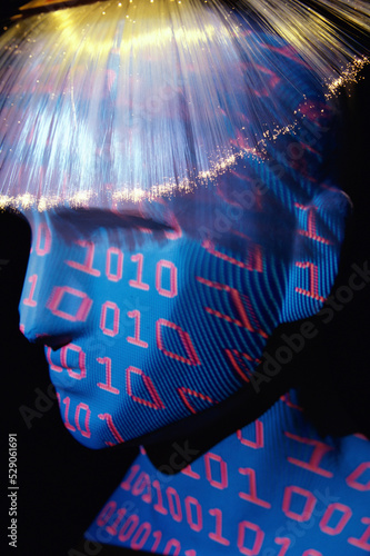 Close-up of a mannequin superimposed with binary code wearing a wig of optical fibers