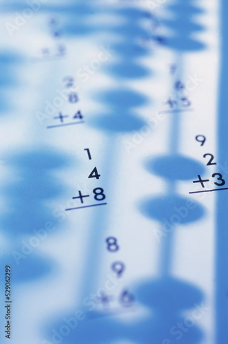 Shadow of an abacus on sheets of paper with calculations