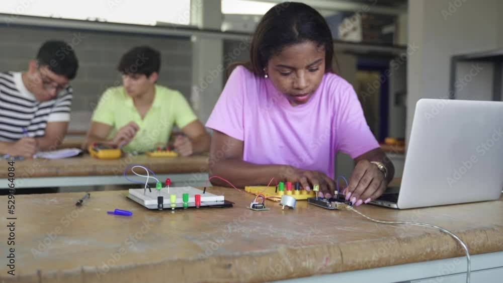 Black female teenager Student programming electronics in the technology course Black female teenager Student programming electronics in the technology course