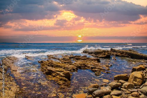 a gorgeous summer landscape at the beach with blue ocean water and sharp rocks long the shore with powerful clouds at sunset at Royal Beach park on White Point Beach in San Pedro California USA