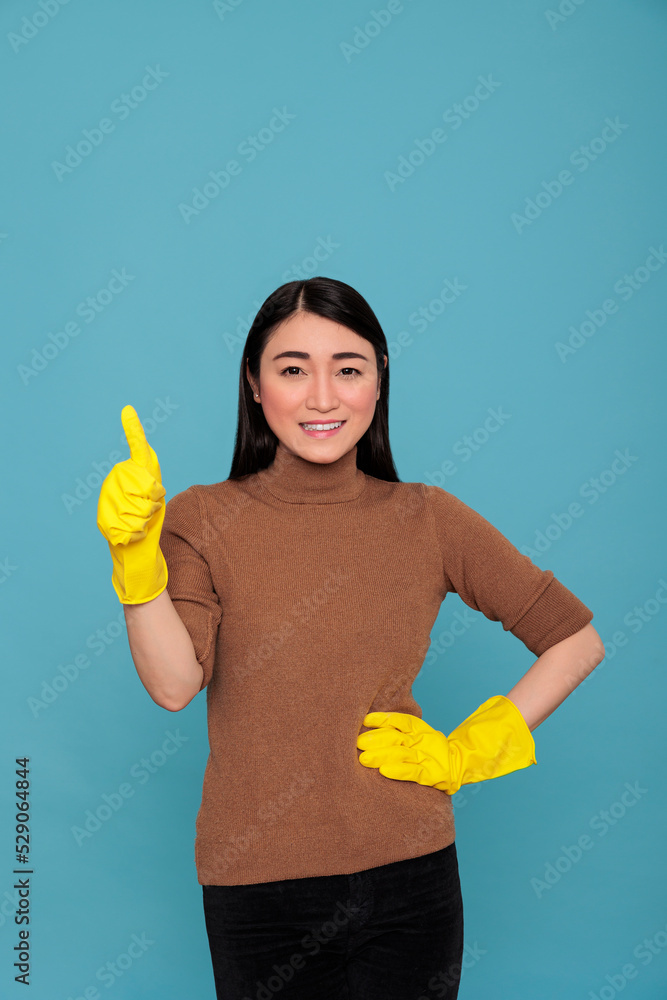 Asian smiling happy asian housemaid thumb up and wearing yellow gloves for hand safety, Cleaning home concept, Pleased laughing and positive state of mind woman ready to do day to day chores Asian smiling happy asian housemaid thumb up and wearing yellow gloves for hand safety, Cleaning home concept, Pleased laughing and positive state of mind woman ready to do day to day chores