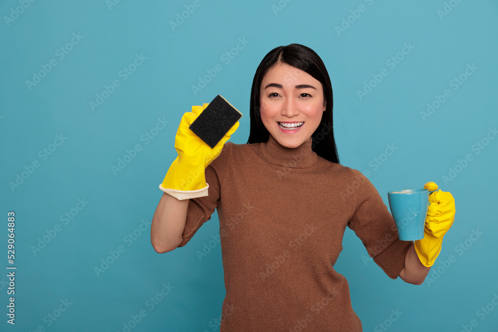 Excited smiling asian young housemaid wearing yellow gloves holding a sponge and coffee cup Cleaning home concept, Refreshment tea at break time, Woman feeling cheerful satisfied and positive Excited smiling asian young housemaid wearing yellow gloves holding a sponge and coffee cup Cleaning home concept, Refreshment tea at break time, Woman feeling cheerful satisfied and positive