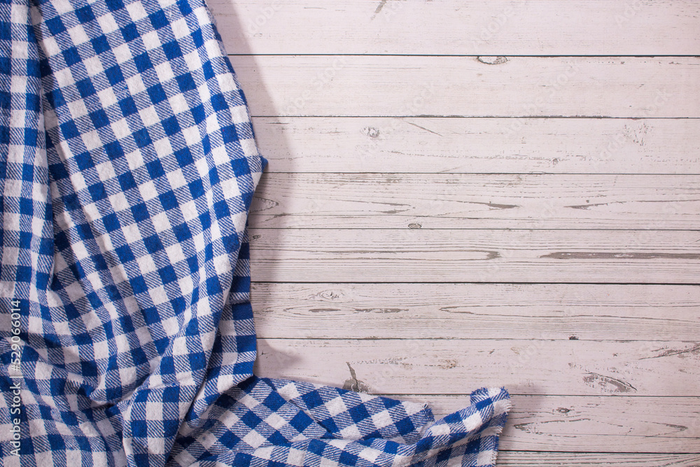 Obraz premium Wooden table with blue and white checkered tablecloth