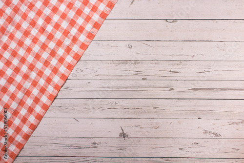 Wooden table with orange and white checkered tablecloth