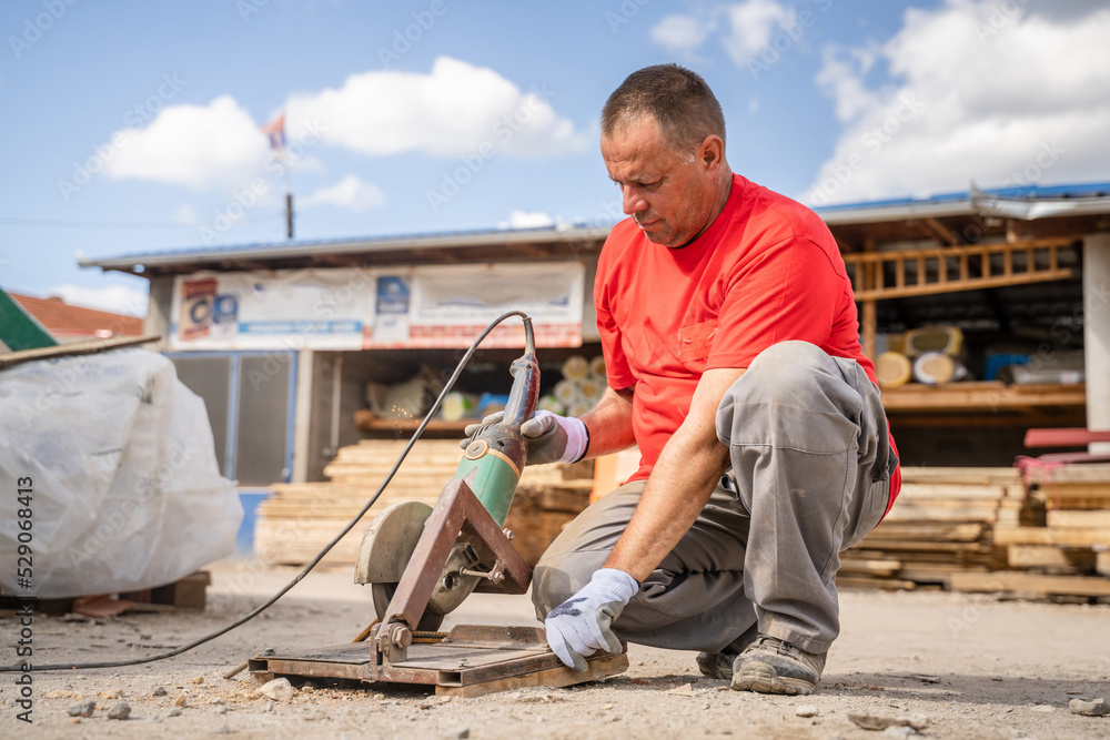 Man use grinder to cut iron armature at warehouse Man use grinder to cut iron armature at warehouse