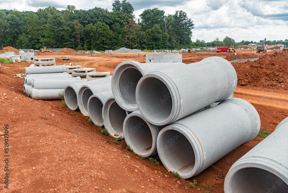 set of new pipes stacked on yellow clay at a construction site. set of new pipes stacked on yellow clay at a construction site.