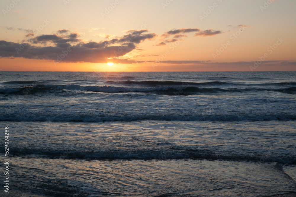 Sunset over the ocean waves