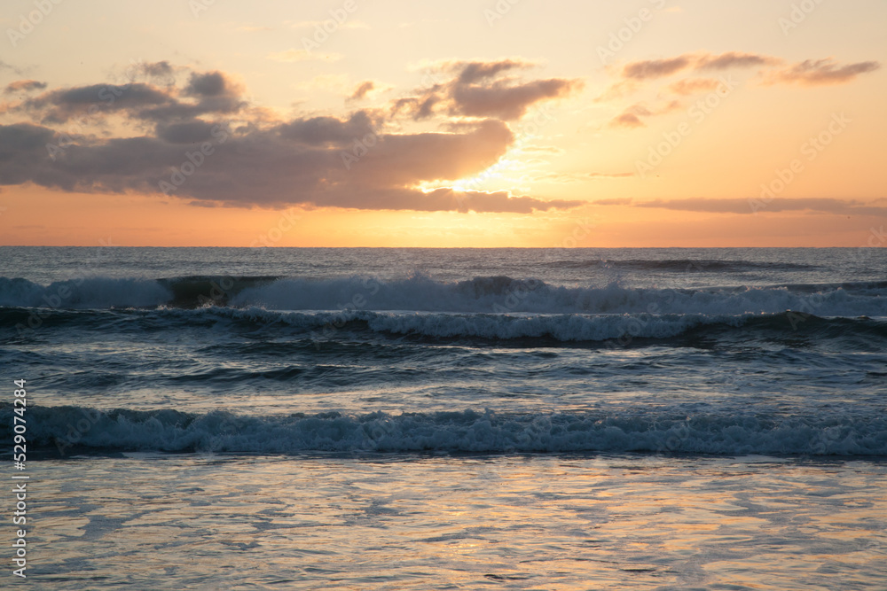 Sunrise over the ocean waves