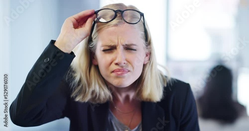 Frowning, confused and poor eyesight with business woman struggling with her eyes or bad vision while wearing glasses in a company office. Portrait of a corporate worker squinting to see clearly photo
