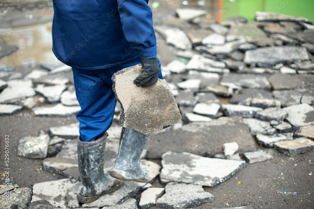 Worker takes broken stone. Cleaning of construction waste. Worker takes broken stone. Cleaning of construction waste.