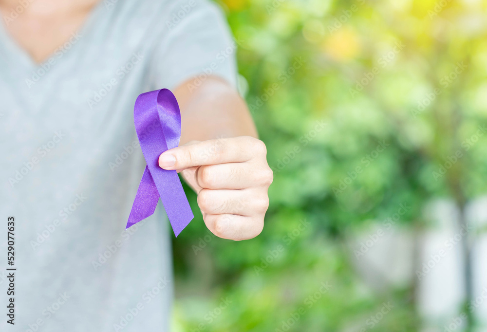 The man in grey shirt show purple in hand on out of focus background. The man in grey shirt show purple in hand on out of focus background.