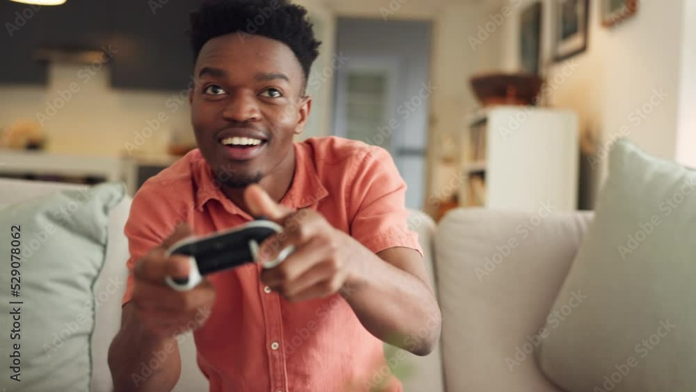 Internet, streaming and online gamer playing video game and sitting on a sofa in living room, excited and energy. Black man enjoying freedom and day off with home entertainment and new subscription Internet, streaming and online gamer playing video game and sitting on a sofa in living room, excited and energy. Black man enjoying freedom and day off with home entertainment and new subscription