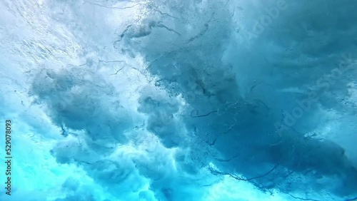 Underwater view of tube wave breaking over coral reef with spinning vortex, clouds. powerful nature, strong wave, danger of drowning. slow motion. photo