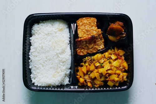 Close-up photo of the food menu in the bento, rice, potatoes, tempeh, and jengkol