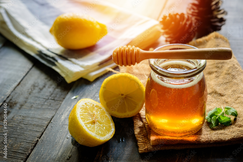 Honey with fresh lemon on wooden table background, honey dipper Honey with fresh lemon on wooden table background, honey dipper