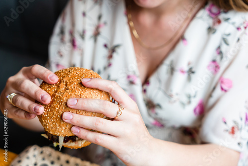 Hamburger eating woman. Hungry Girl Biting Burger. Fast food, people and unhealthy eating concept.