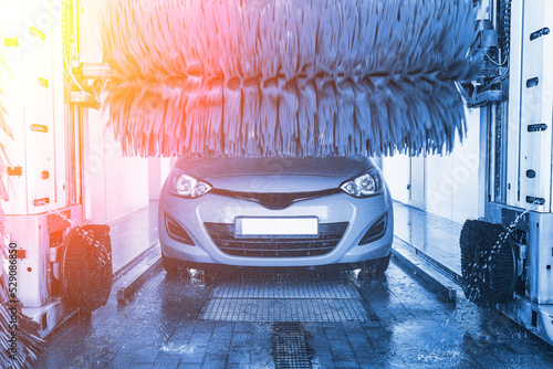 Car wash background automatic carwash. Brush washer clean blue auto car on automatic carwash station. Automated car washing service. photo