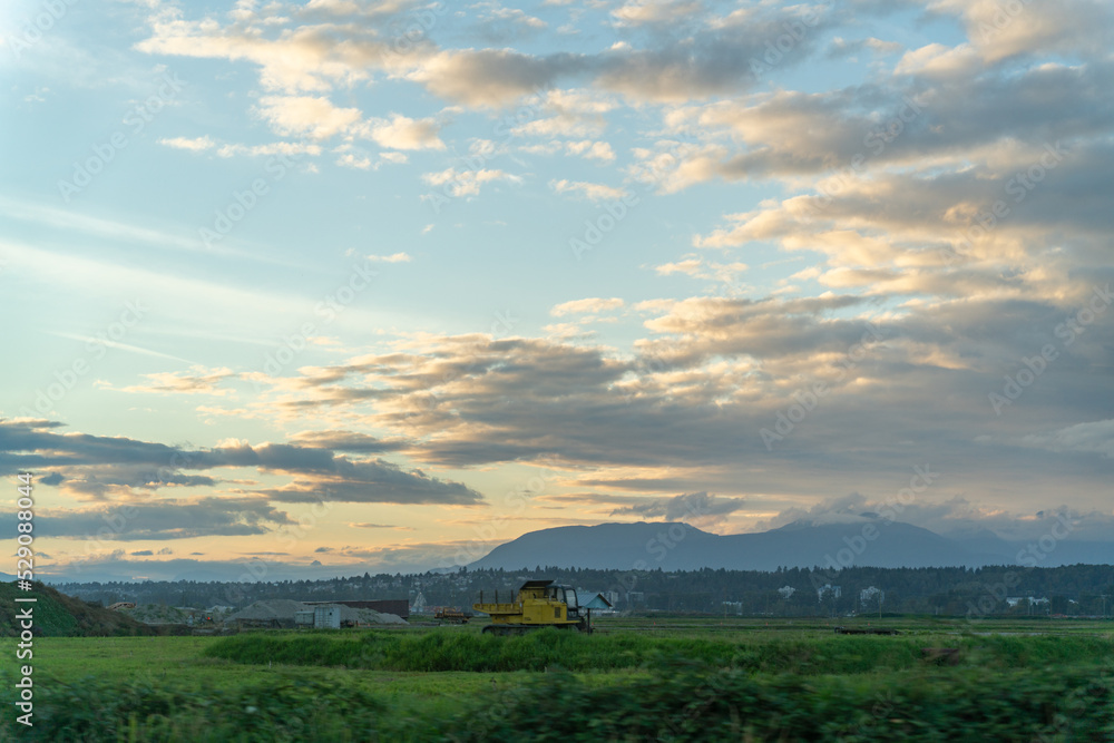 Fototapeta premium farm land in the city. sunset, moiuntain, clouds