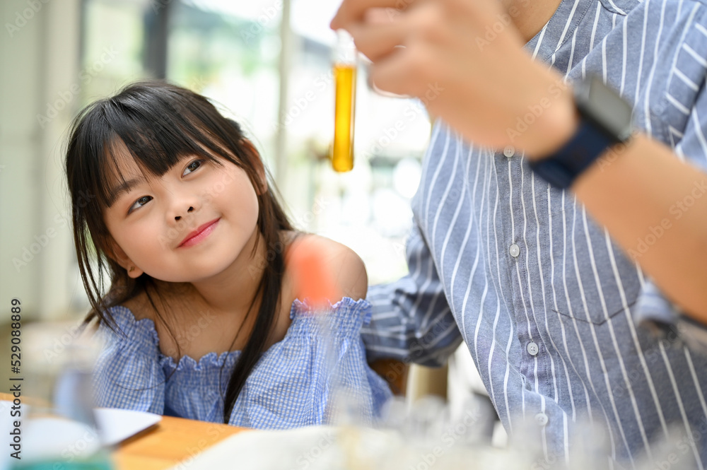 A pretty young Asian girl studying science, learning chemical experiment from her teacher A pretty young Asian girl studying science, learning chemical experiment from her teacher