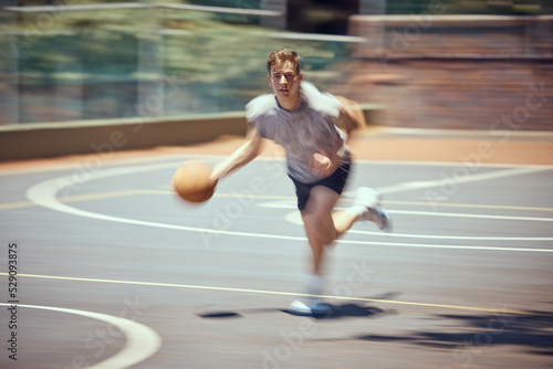 Basketball player, sports and training with a active, fit and fast man playing a game at an outdoor court. Professional athlete doing exercise for health and wellness during practice for a match