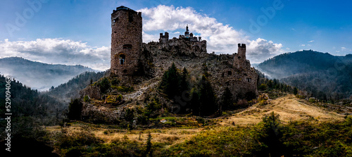 Print op canvas A lonely abandoned castle in the mountains with dramatic sky background