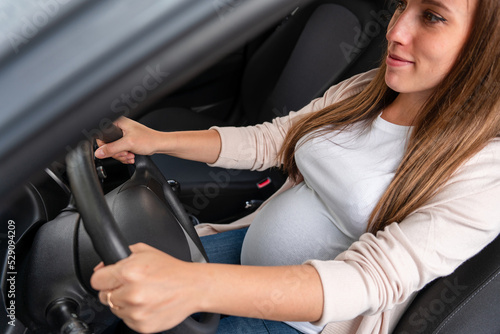 Pregnancy woman driving car. Young smiling pregnant woman driving car. Safety pregnancy young mother drive concept.